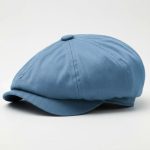 Casquette gavroche bleu ciel posée sur fond blanc, photo studio produit e-commerce