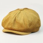 Casquette gavroche velours jaune sur fond blanc, photo studio